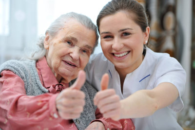 elderly and caregiver doing a thumbs up